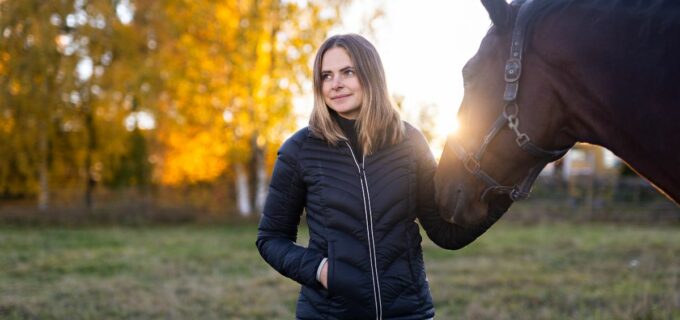 Kvinna står med häst