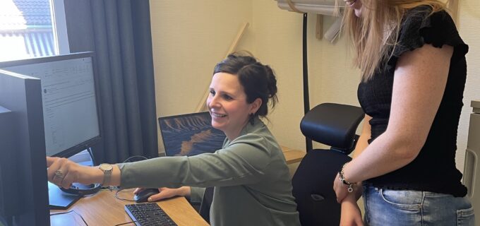 två medarbetare diskuterar och pekar på en skärm.