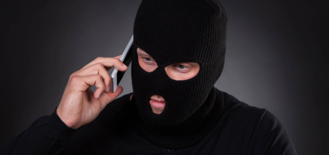 Man i rånarluva som pratar i mobiltelefon