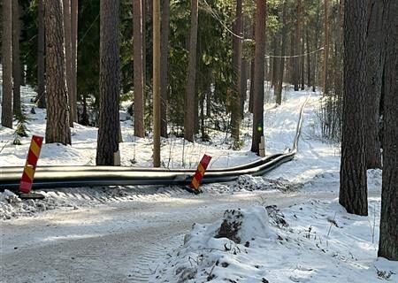 Ledningar ligger längs en stig i väntan på att placeras i backen.